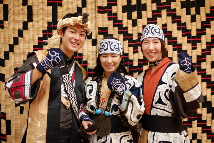 Mengenakan baju tradisional Ainu 