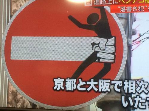 Seorang seniman bermain-main dengan rambu lalu lintas dan bermasalah dengan Polisi Jepang
